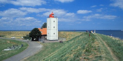 Enkhuizen (NL). The lighthouse De Ven at the Ijsselmeer a little north of Enkhuizen. The lighthouse was built in 1700 and is the last of three identical lighthouses erected to guide the ships from the North Sea into Amsterdam. The town was founded in 1355 and enjoyed a golden age thanks to the herring fishery and trade with East India until the nineteenth century, peaking in the mid-seventeenth century. The town is now Holland�s centre for traditional sailboats. 